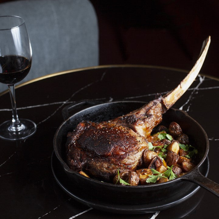 Tomahawk con mantequilla y papas